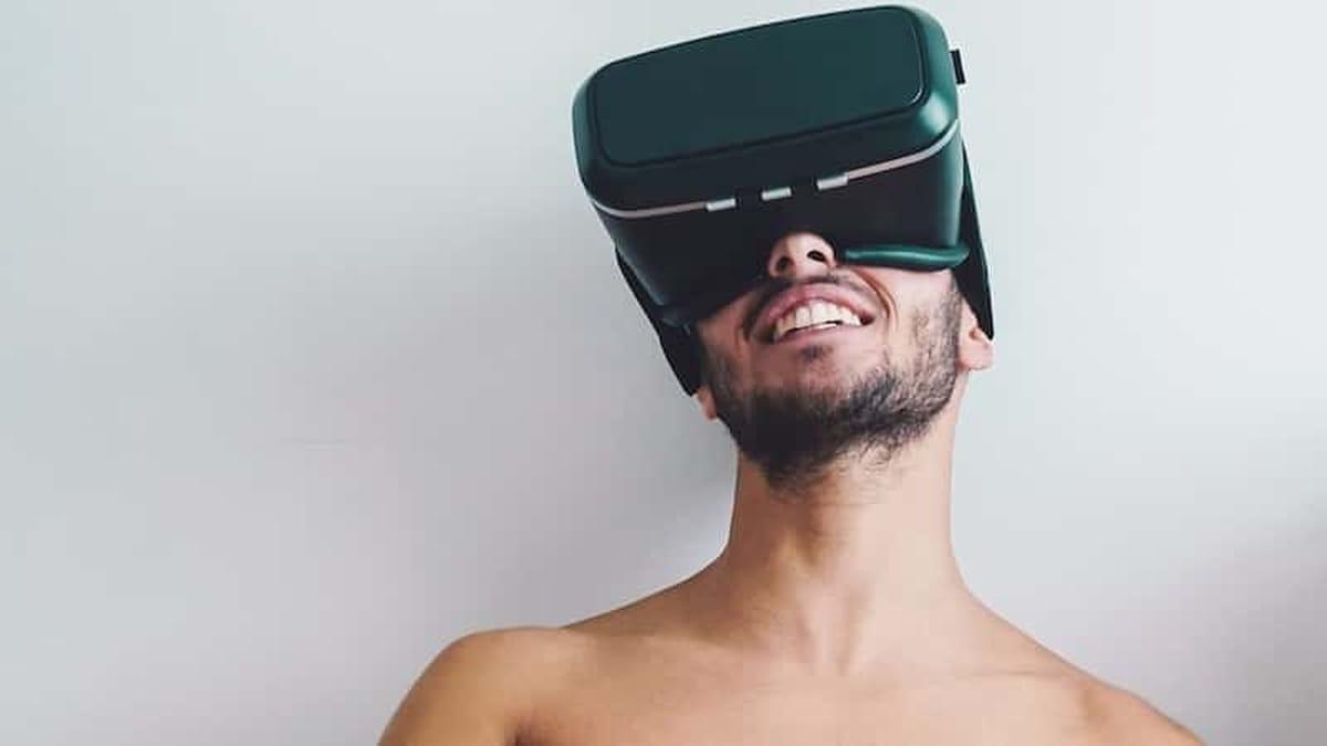 Een man met bloot bovenlijf die kijkt met virtual reality bril